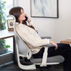 Woman in cream sweater reclining in a cloud white Vari Align office chair with Alloy Grey cushioning, talking on the phone beside a desk in an office.